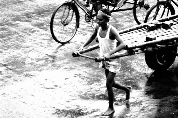 Man pulling two wheeled cart in Dhaka
