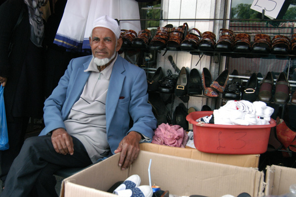 Shopkeeper sitting outside his shop, Whitechapel 2008