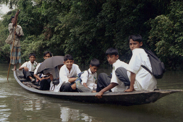 Pupils in a boat taking them back to their village. Sylhet, Bangladesh 1991