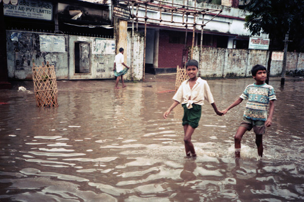 Boys walking in a flooded street. Dhaka, Bangladesh