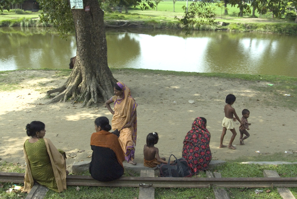 Women and children look out towards a river from the railway track they have occupied. Bangladesh 2008