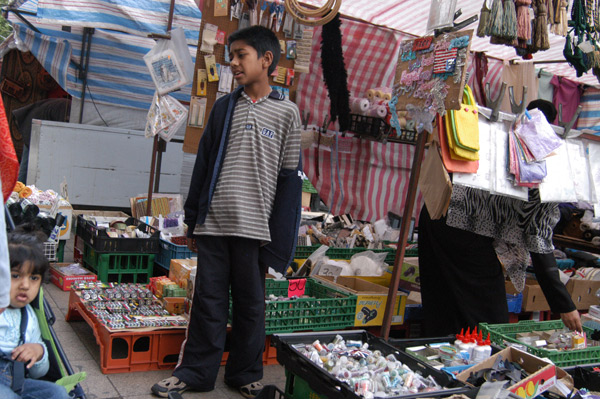 Boy looks after market stall. Whitechapel Road 2007