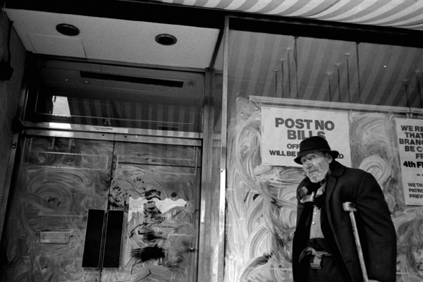Man outside closed shop. Whitechapel Rd, 1982