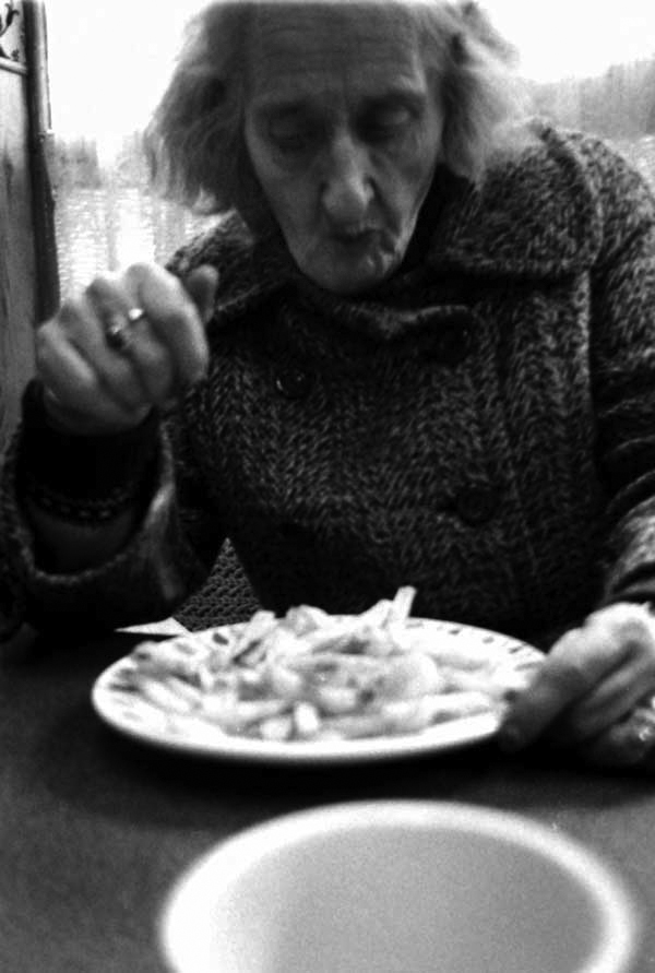Woman eating a plate of chips, Cheshire Street London c.1984