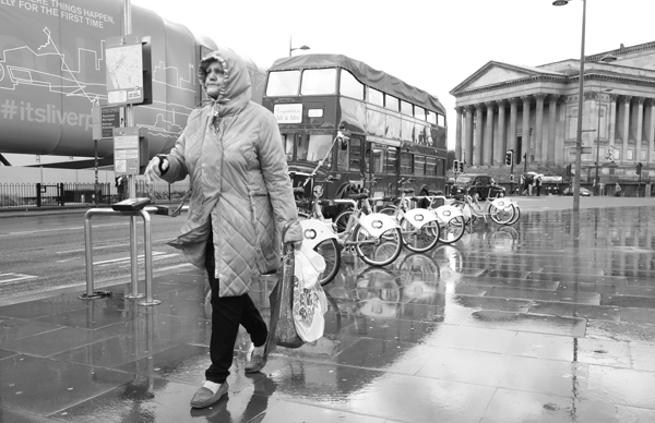 Woman wearing a hood in the rain. Lime Street. Liverpool September 2017.