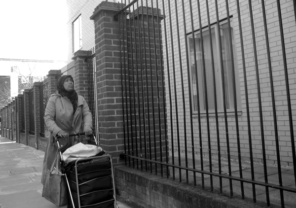 Woman with a shopping trolley. Old Montague Street. Spitalfields, East London 2010. 
