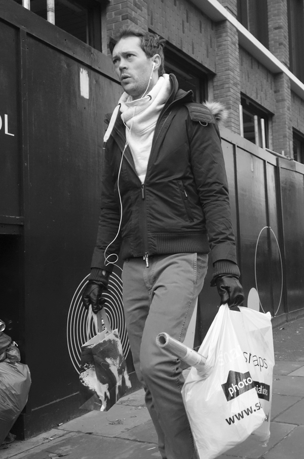 Man with shopping in Commercial Street. Spitalfields December 2017.