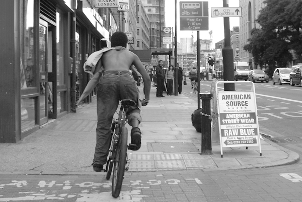 Cyclist on the pavement. Commercial Road. East London, August 2008.