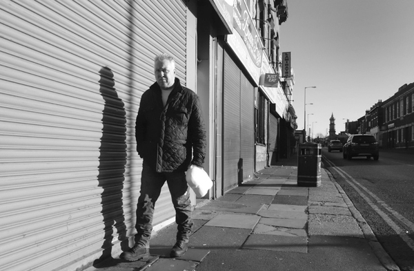 Man with a shadow on Wavertree High Street. Liverpool, January 2018.