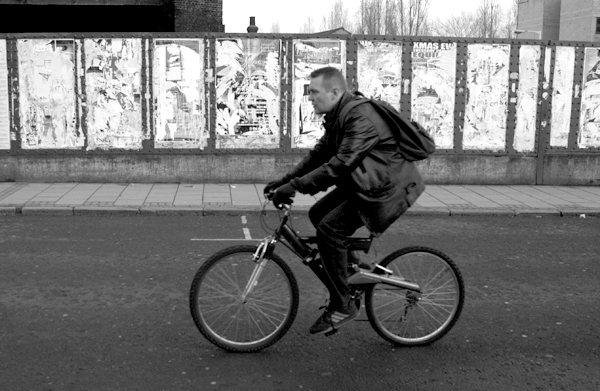Cyclist crossing the bridge on Brick Lane. East London 2002. 