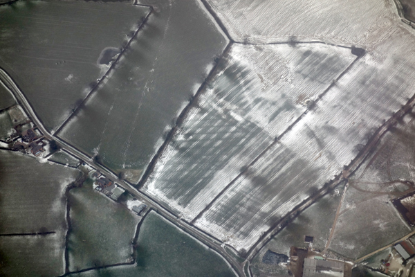 Graphic view of fields and snow during descent into Manchester airport. March 2018.