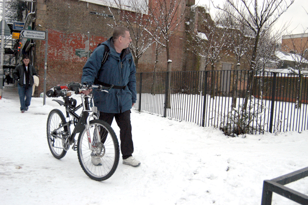 Man with a bike in the snow in Vallance Road. East London, January 2002.