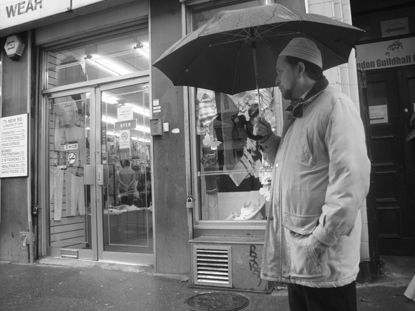 Man with an umbrella. Bethnal Green Road. East London 2010.